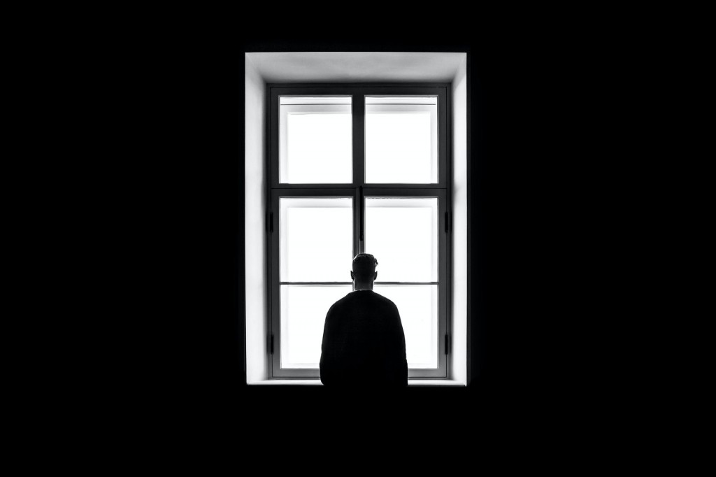 Тъмен прозорец и човек пред прозореца
